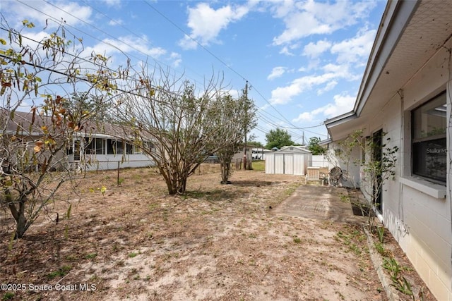 view of yard featuring an outdoor structure, a shed, and fence