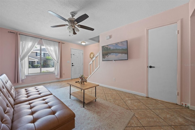 130 Kristi Ann Ct, Winter Springs, FL 32708 - tiled living area featuring baseboards, a ceiling fan, stairs, and a textured ceiling
