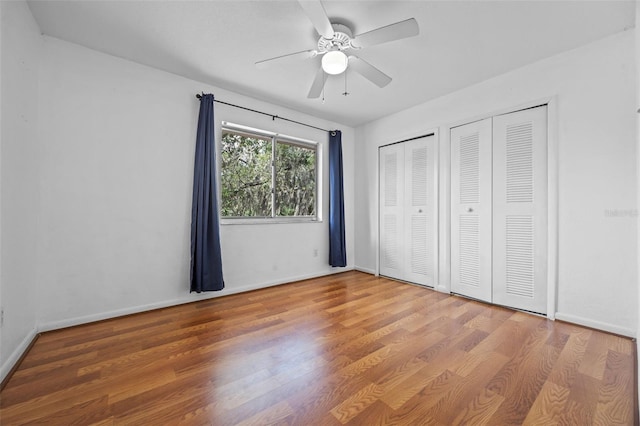 130 Kristi Ann Ct, Winter Springs, FL 32708 - unfurnished bedroom with a ceiling fan, baseboards, multiple closets, and wood finished floors