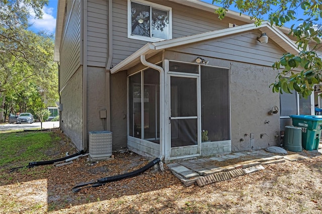 130 Kristi Ann Ct, Winter Springs, FL 32708 - back of house with central AC unit, a sunroom, and stucco siding