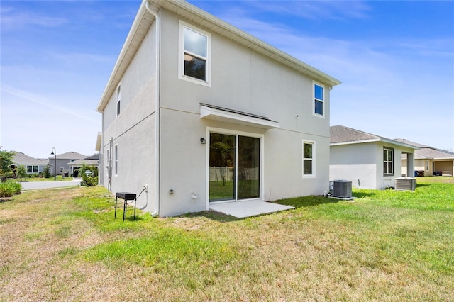 rear view of property with a lawn, central AC unit, and stucco siding