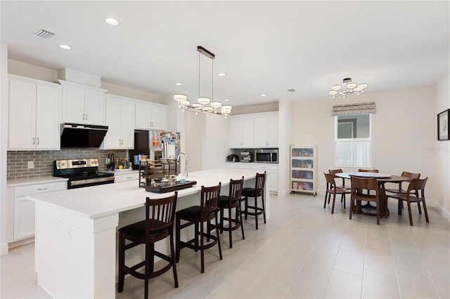 kitchen featuring a large island, visible vents, appliances with stainless steel finishes, tasteful backsplash, and light countertops