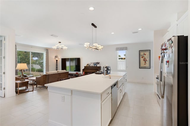 kitchen featuring light countertops, white cabinetry, appliances with stainless steel finishes, light tile patterned floors, and a notable chandelier
