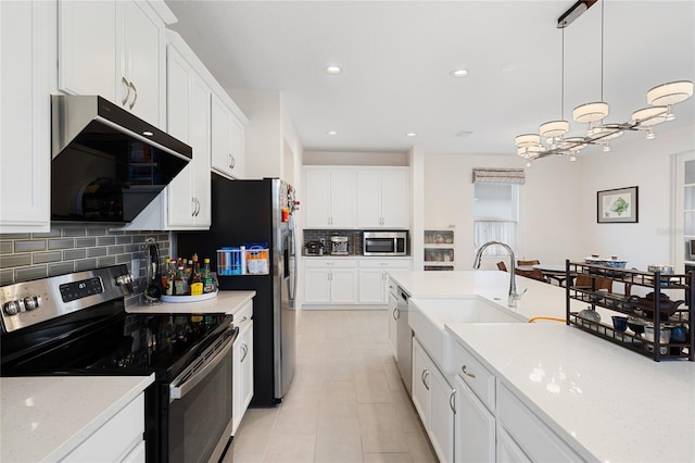kitchen featuring backsplash, appliances with stainless steel finishes, a sink, ventilation hood, and white cabinets