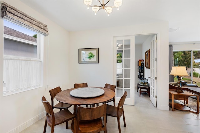 dining area featuring baseboards, an inviting chandelier, and light tile patterned floors