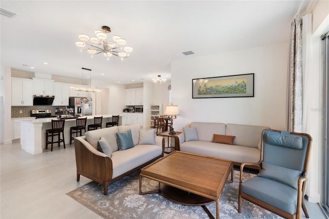 living area featuring visible vents and a notable chandelier