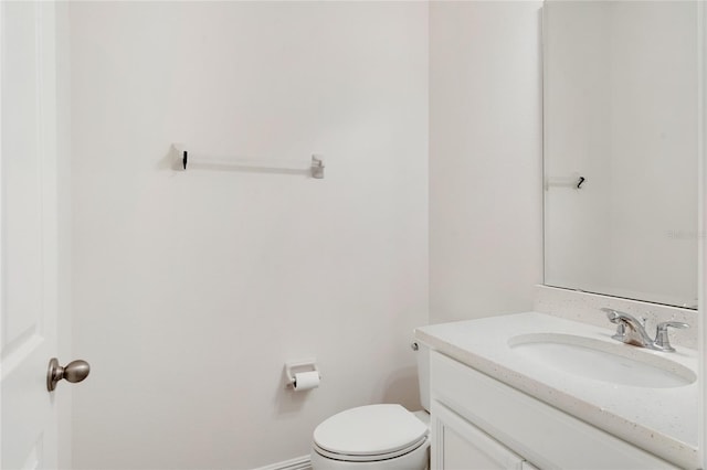 bathroom featuring vanity, baseboards, and toilet