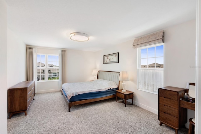 carpeted bedroom with baseboards and multiple windows