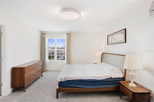 bedroom featuring baseboards and light carpet