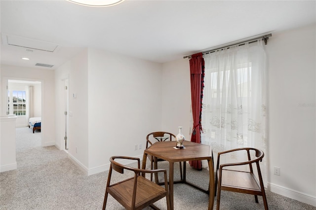 dining room featuring baseboards, visible vents, and light colored carpet