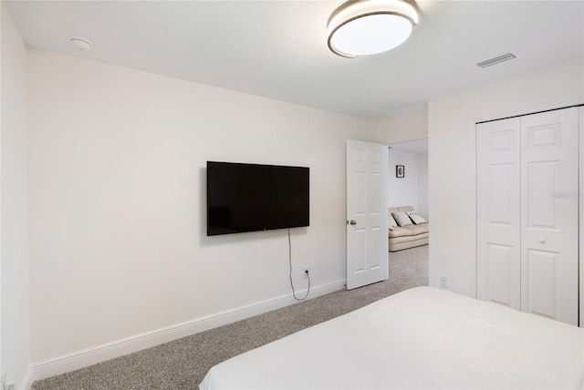 carpeted bedroom featuring baseboards, visible vents, and a closet