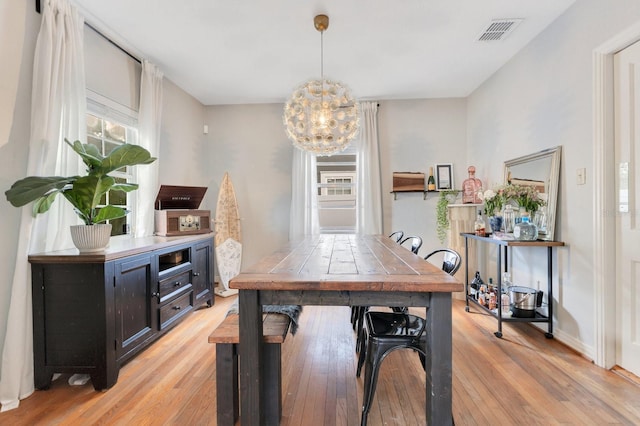 home office with visible vents, a chandelier, a wealth of natural light, and light wood-type flooring