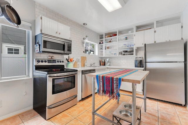 kitchen with light countertops, light tile patterned floors, decorative backsplash, and stainless steel appliances