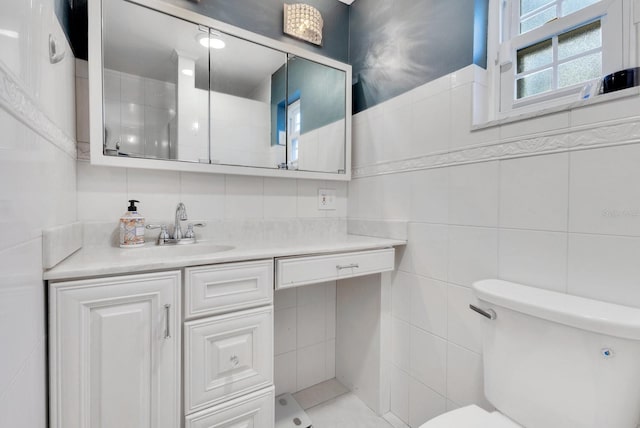 bathroom featuring tile walls, vanity, and toilet