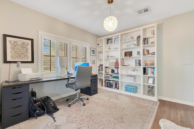 office area featuring baseboards, visible vents, an inviting chandelier, and wood finished floors