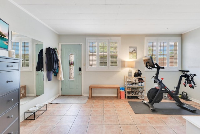 exercise room with light tile patterned floors, baseboards, and ornamental molding