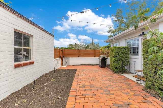 view of patio with area for grilling and fence