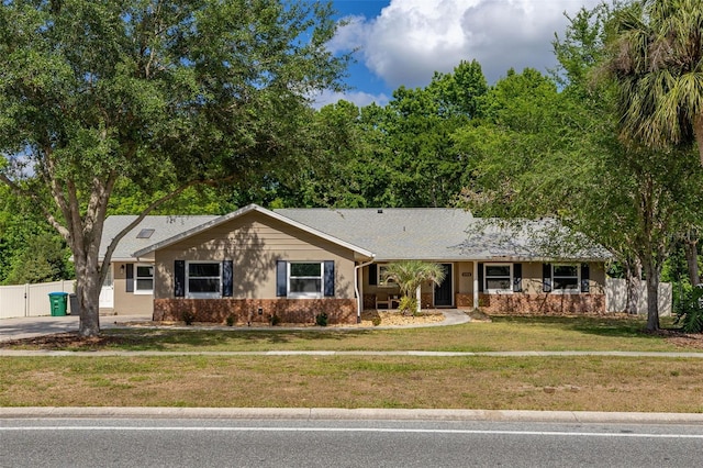 ranch-style house featuring fence and a front yard