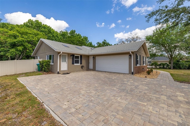single story home with fence, an attached garage, driveway, and stucco siding
