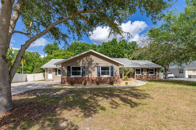 ranch-style home featuring driveway, a front yard, a gate, brick siding, and fence