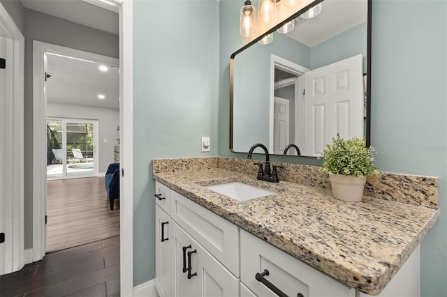 bathroom with baseboards, vanity, and wood finished floors