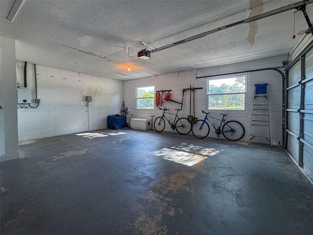 garage with a garage door opener and concrete block wall