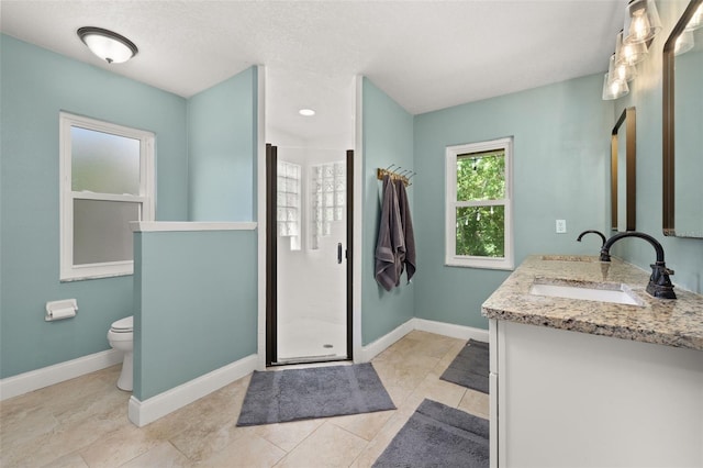 bathroom featuring double vanity, toilet, baseboards, a shower stall, and a sink