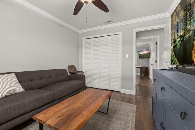 living room featuring crown molding, ceiling fan, visible vents, and dark wood-type flooring