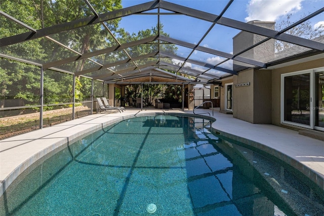 pool featuring glass enclosure and a patio area