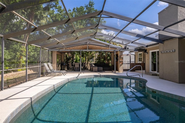 outdoor pool featuring a patio, glass enclosure, and outdoor lounge area