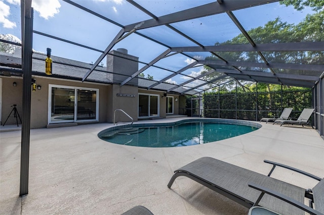 pool with glass enclosure and a patio