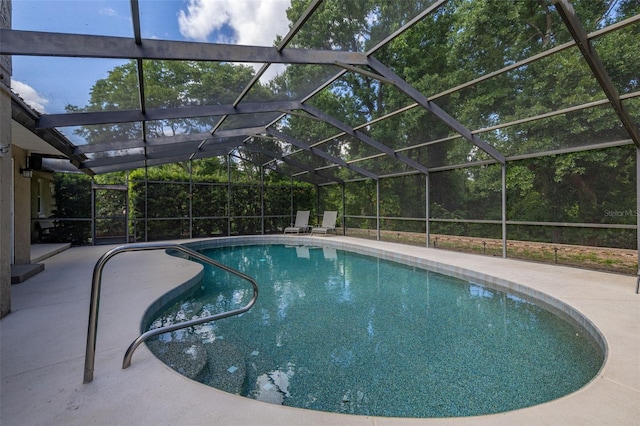 outdoor pool with glass enclosure and a patio area