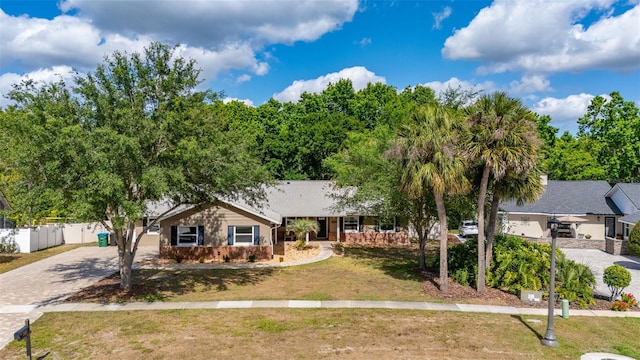 ranch-style house featuring fence, driveway, and a front lawn