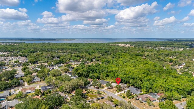 drone / aerial view featuring a residential view, a water view, and a wooded view