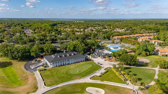 drone / aerial view featuring view of golf course and a wooded view