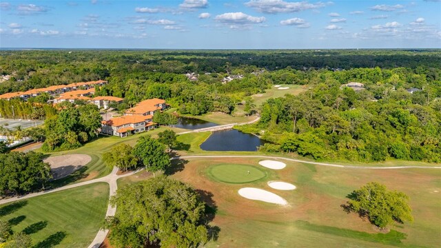 bird's eye view featuring a forest view, view of golf course, and a water view