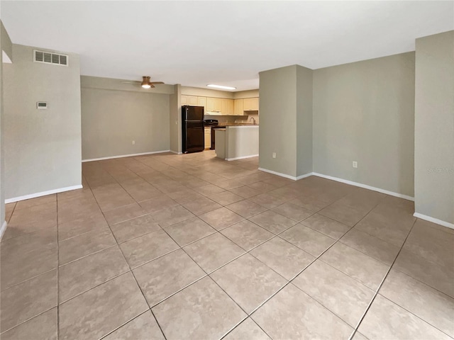 unfurnished living room featuring baseboards, a ceiling fan, light tile patterned flooring, and visible vents