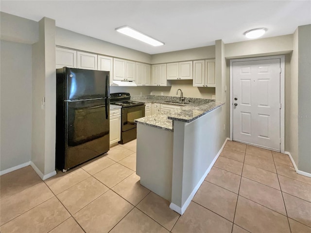 kitchen featuring a peninsula, baseboards, under cabinet range hood, a sink, and black appliances