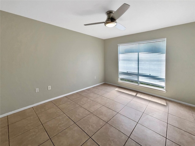 spare room with baseboards, ceiling fan, and tile patterned floors