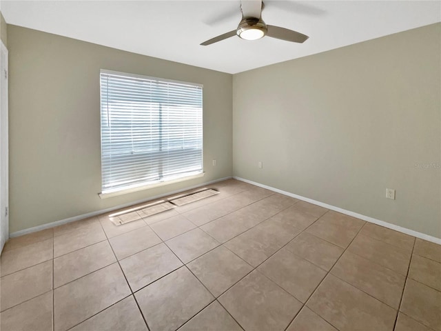 unfurnished room with baseboards, ceiling fan, and tile patterned floors