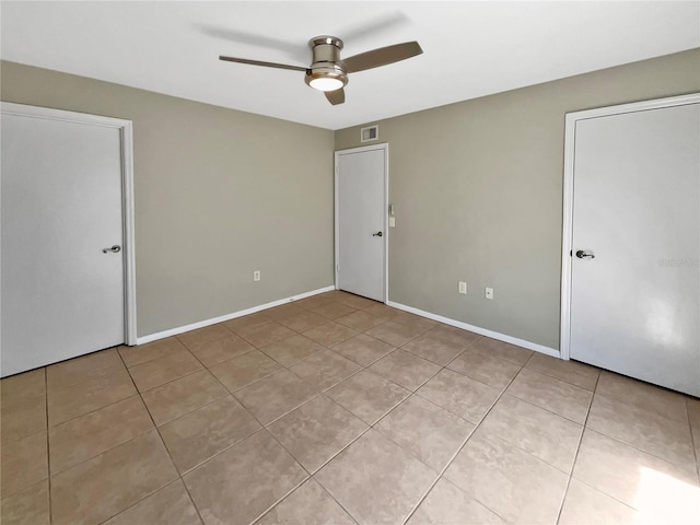 unfurnished bedroom featuring visible vents, baseboards, ceiling fan, and light tile patterned floors