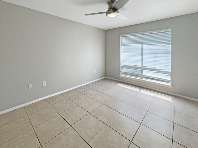 spare room featuring baseboards, ceiling fan, and light tile patterned flooring