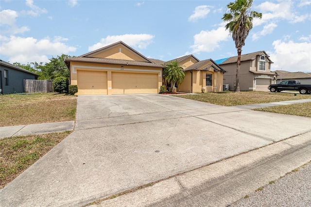 ranch-style home with stucco siding, concrete driveway, and a front yard