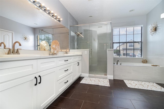full bathroom with a sink, double vanity, tile patterned floors, a shower stall, and a garden tub
