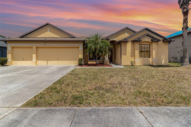 ranch-style home with an attached garage, a front lawn, stucco siding, and driveway