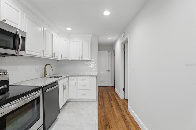 320 Lakeview St Unit 222, Orlando, FL 32804 - kitchen featuring stainless steel appliances, a sink, white cabinets, decorative backsplash, and recessed lighting