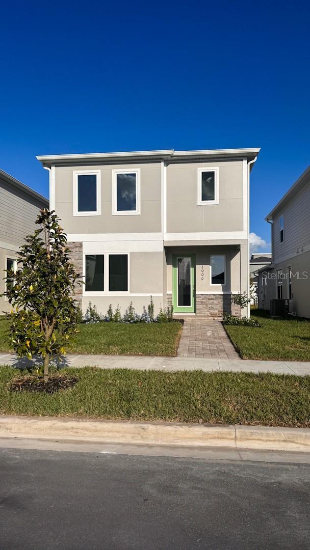 1999 Iorio St, Saint Cloud, FL 34771 - view of front of home with a front yard, stone siding, and stucco siding