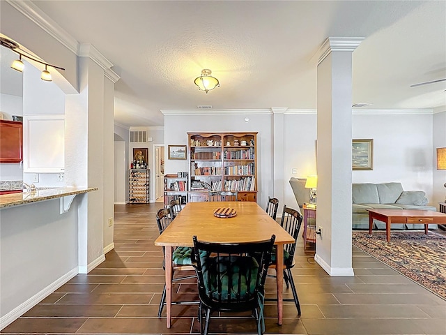 dining room featuring baseboards, visible vents, ornamental molding, and wood tiled floor