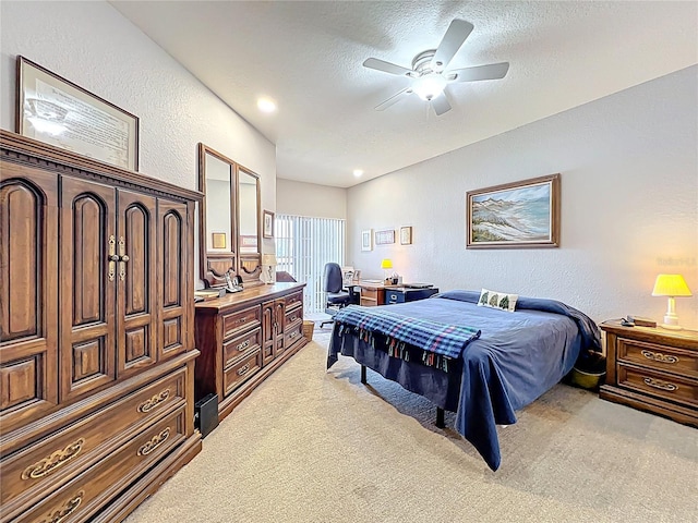 bedroom featuring ceiling fan, a textured wall, light carpet, and a textured ceiling