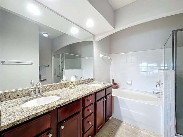bathroom featuring a sink, a shower with shower door, a bathtub, and double vanity